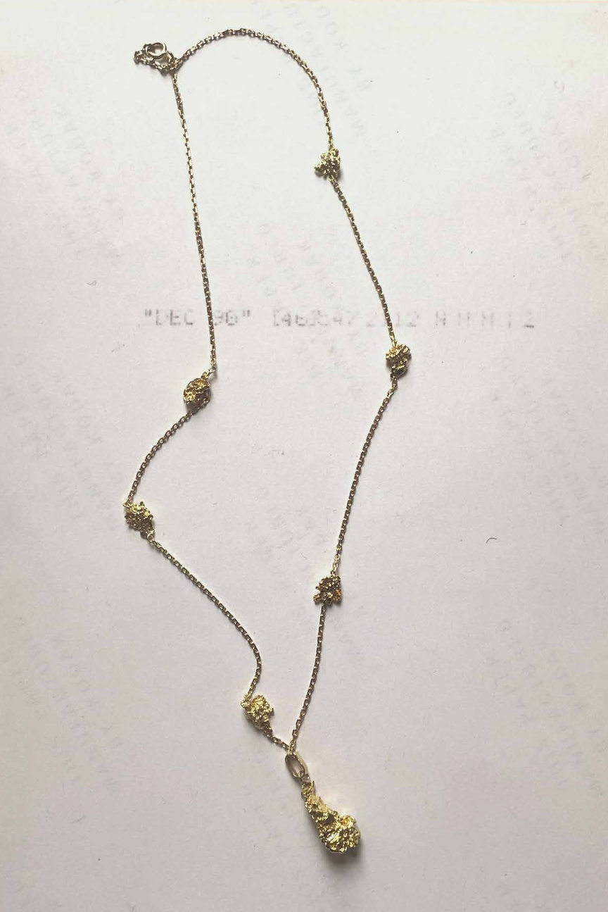 Gold necklace with floral and bead details.