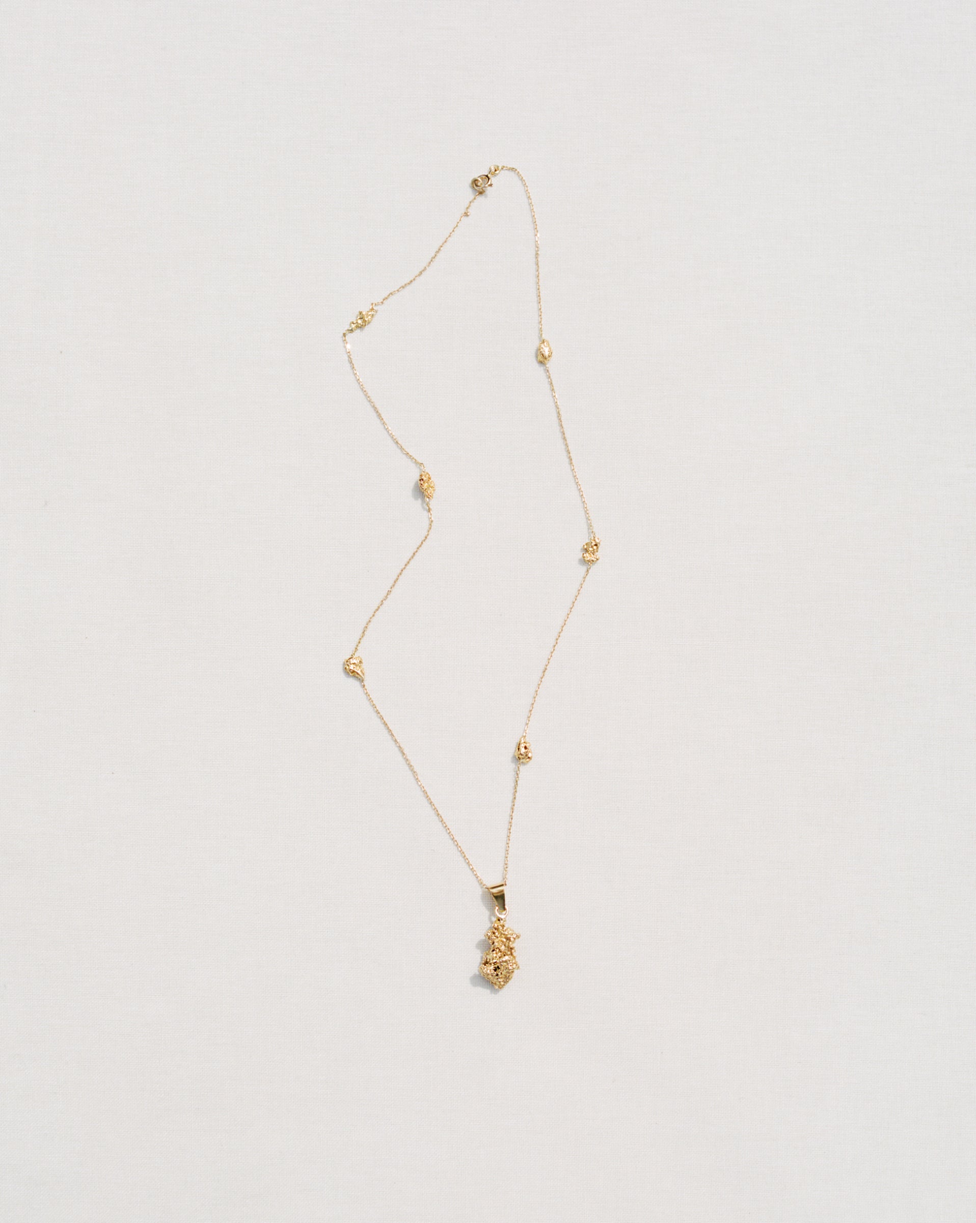 Collier Honegger en or avec pendentif sur fond blanc