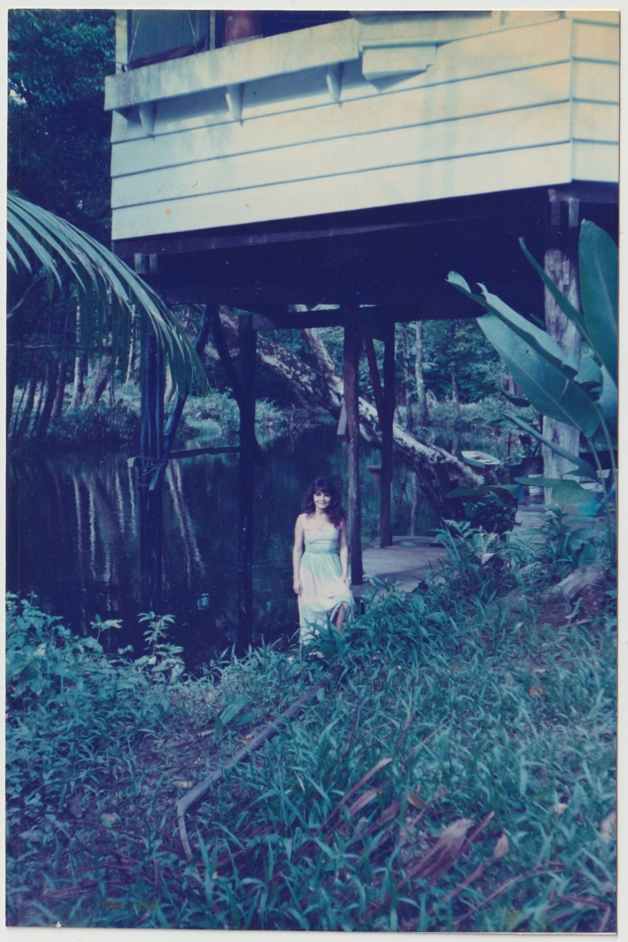Woman beside a river and a building in the jungle